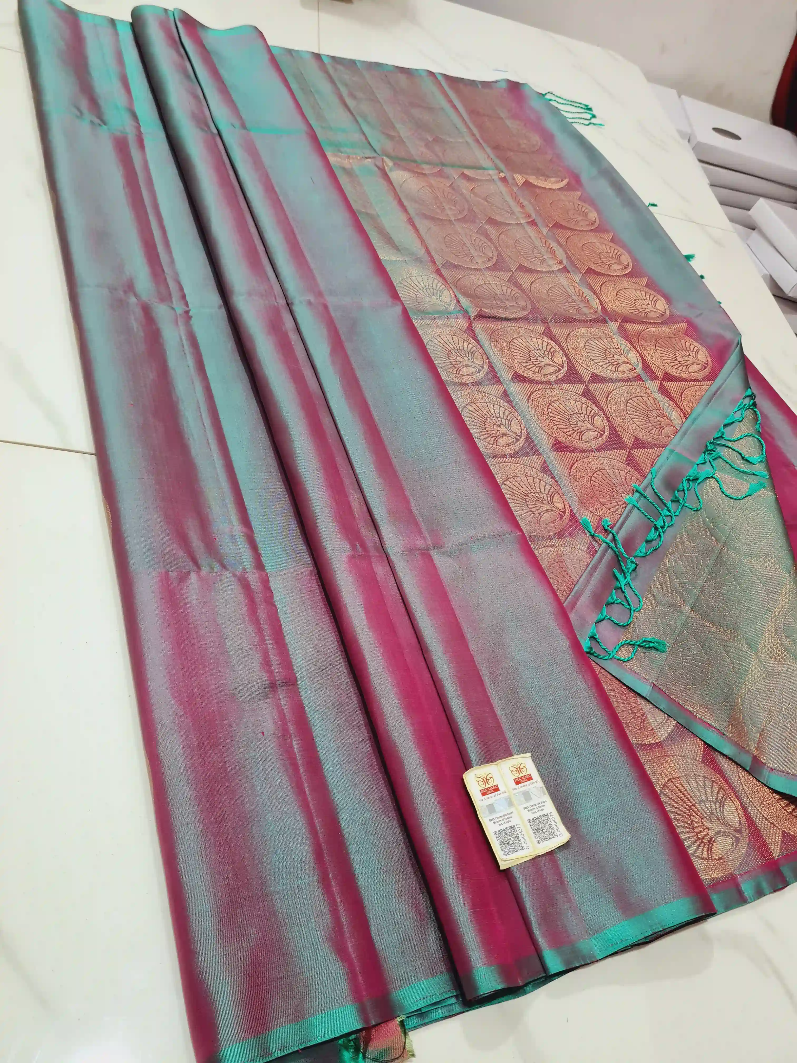 Kanchipuram soft silk saree in dual-tone teal and magenta with a rich gold pallu featuring circular floral motifs