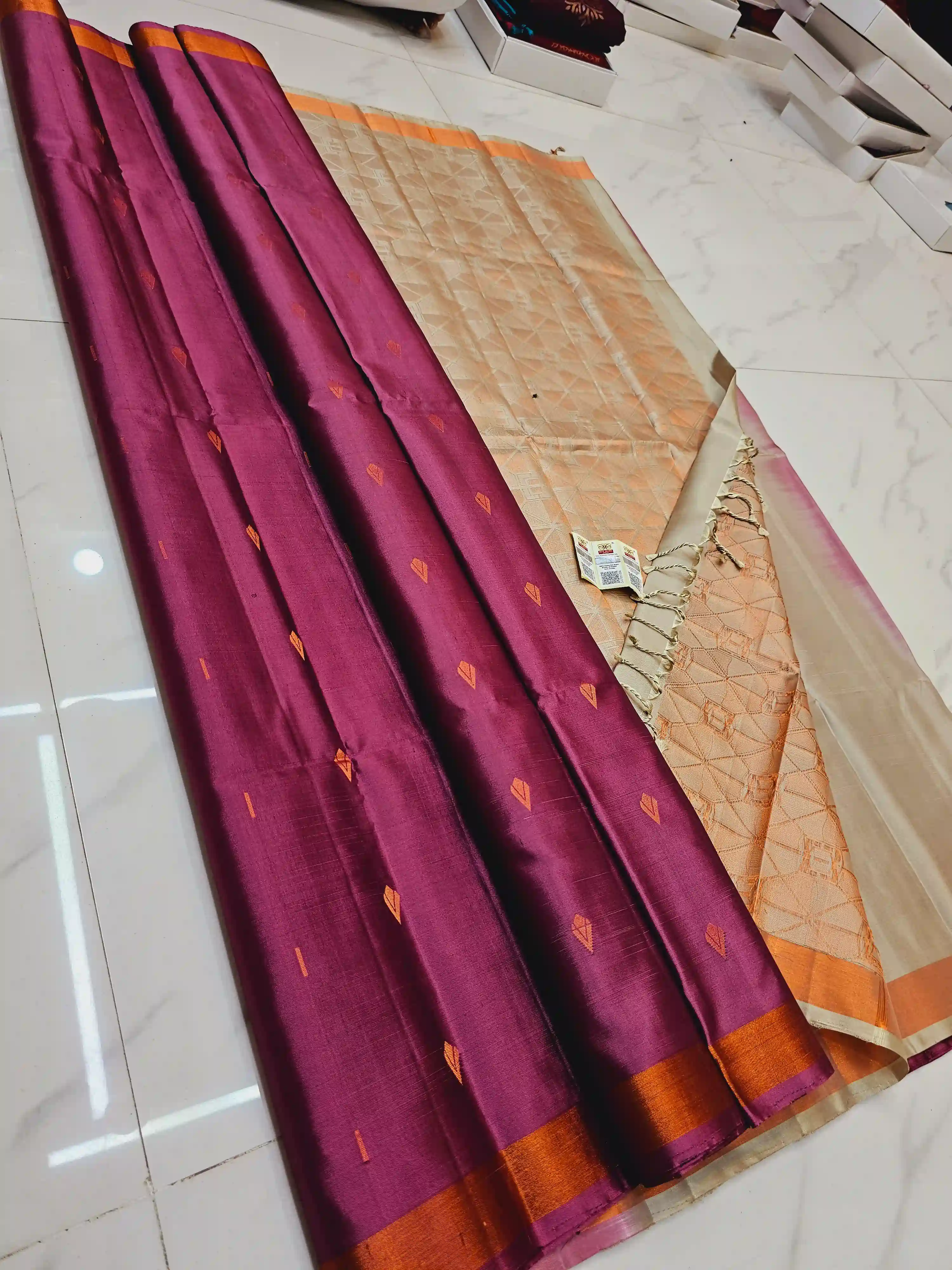 Kanchipuram soft silk saree in deep magenta with orange zari border and subtle geometric motifs